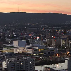 Oslo skyline i solnedgang med operaen og Bjørvika under oppføring.