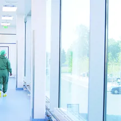 A health care worker walking down a hospital hallway.