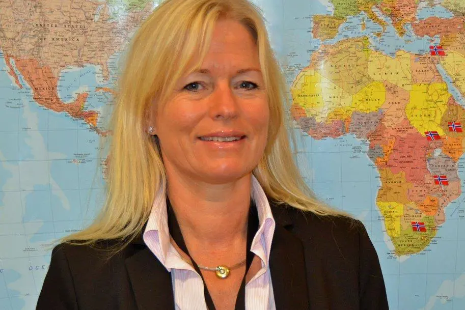 En person som smiler foran et kart