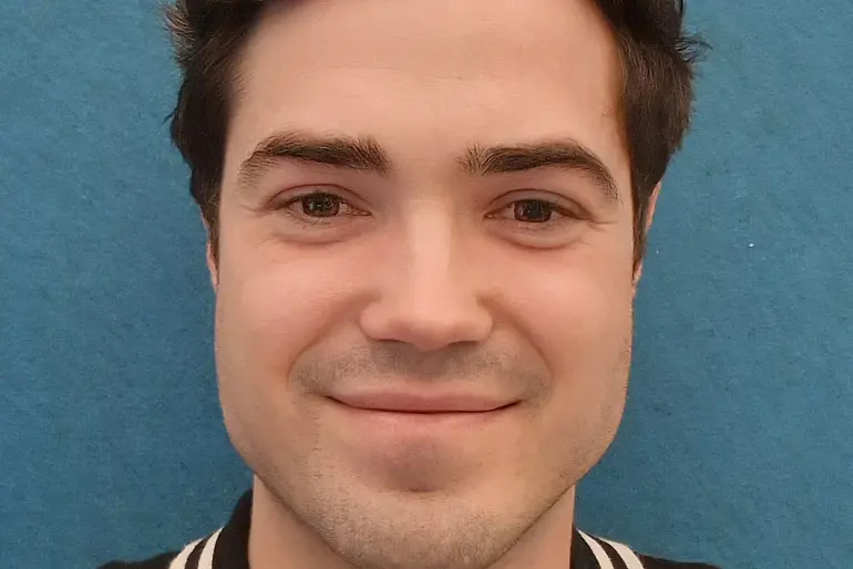 En mann som smiler til kameraet