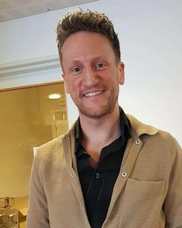 En mann som smiler til kameraet