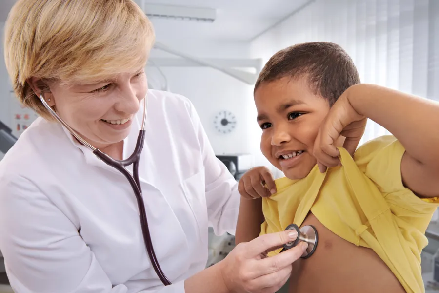 Helsepersonell som lytter på lungene til et barn