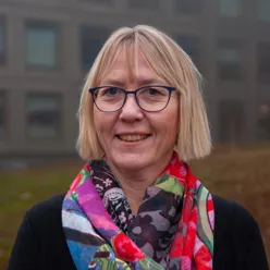 A person wearing glasses and a scarf