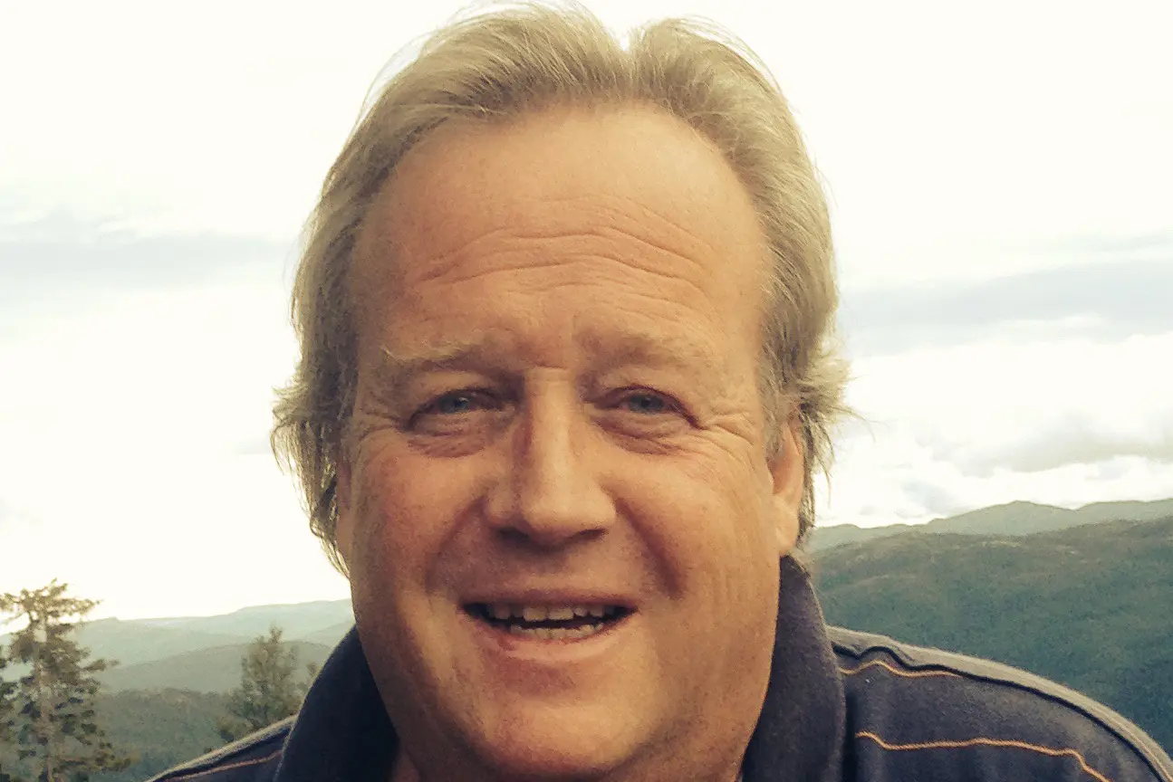 En mann som smiler til kameraet