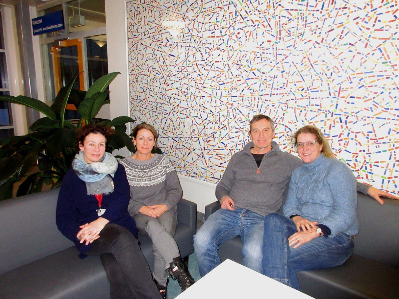 En gruppe mennesker som sitter i en sofa