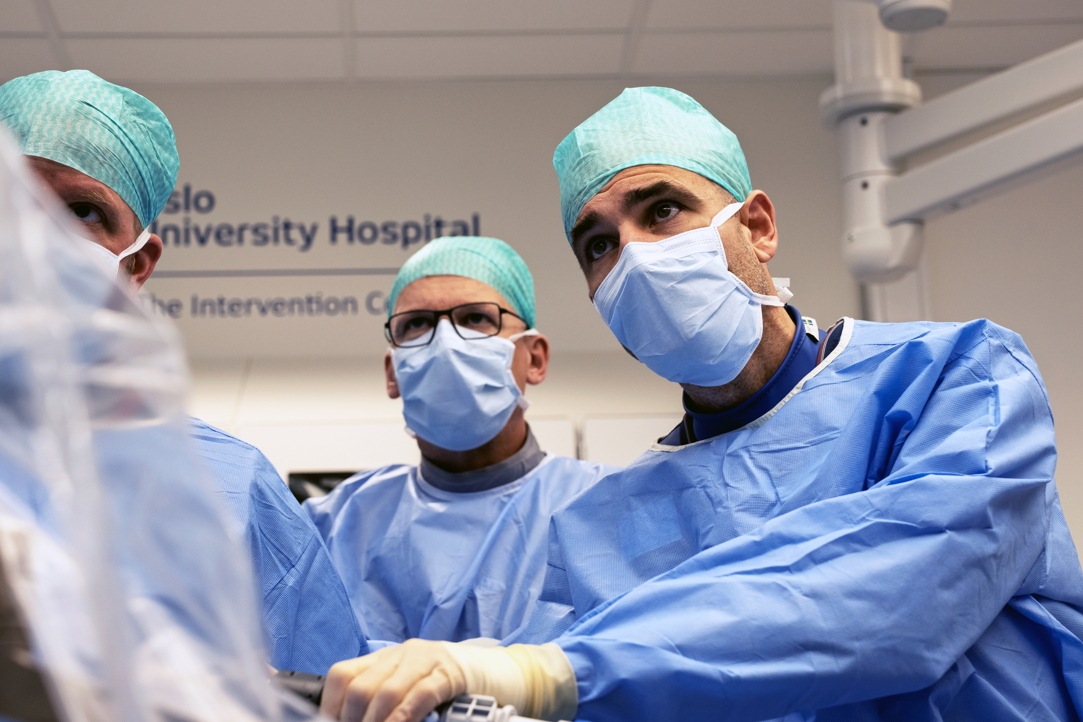 tre kirurger i grønt som observerer