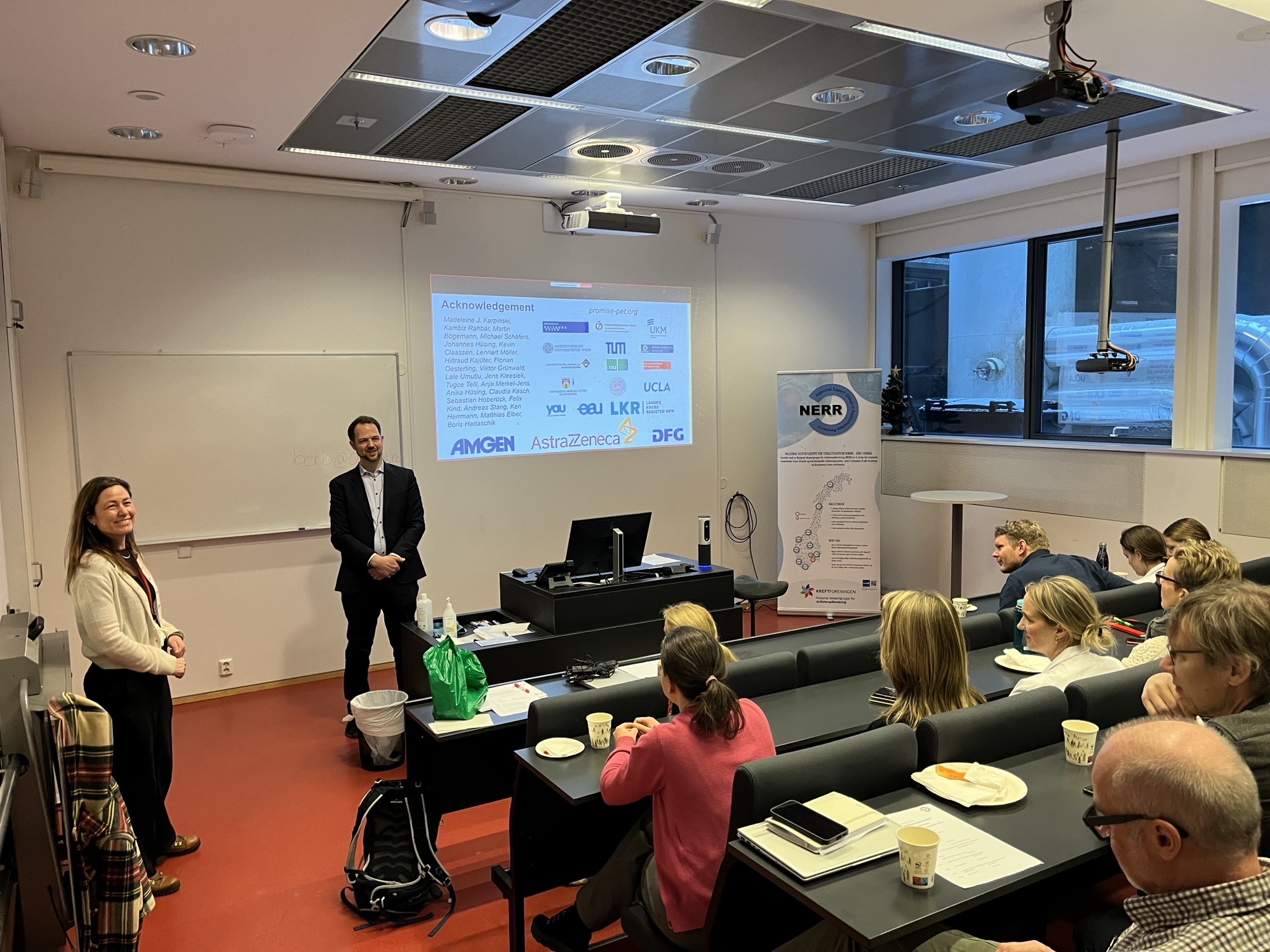 To personer som holder en presentasjon for en gruppe mennesker