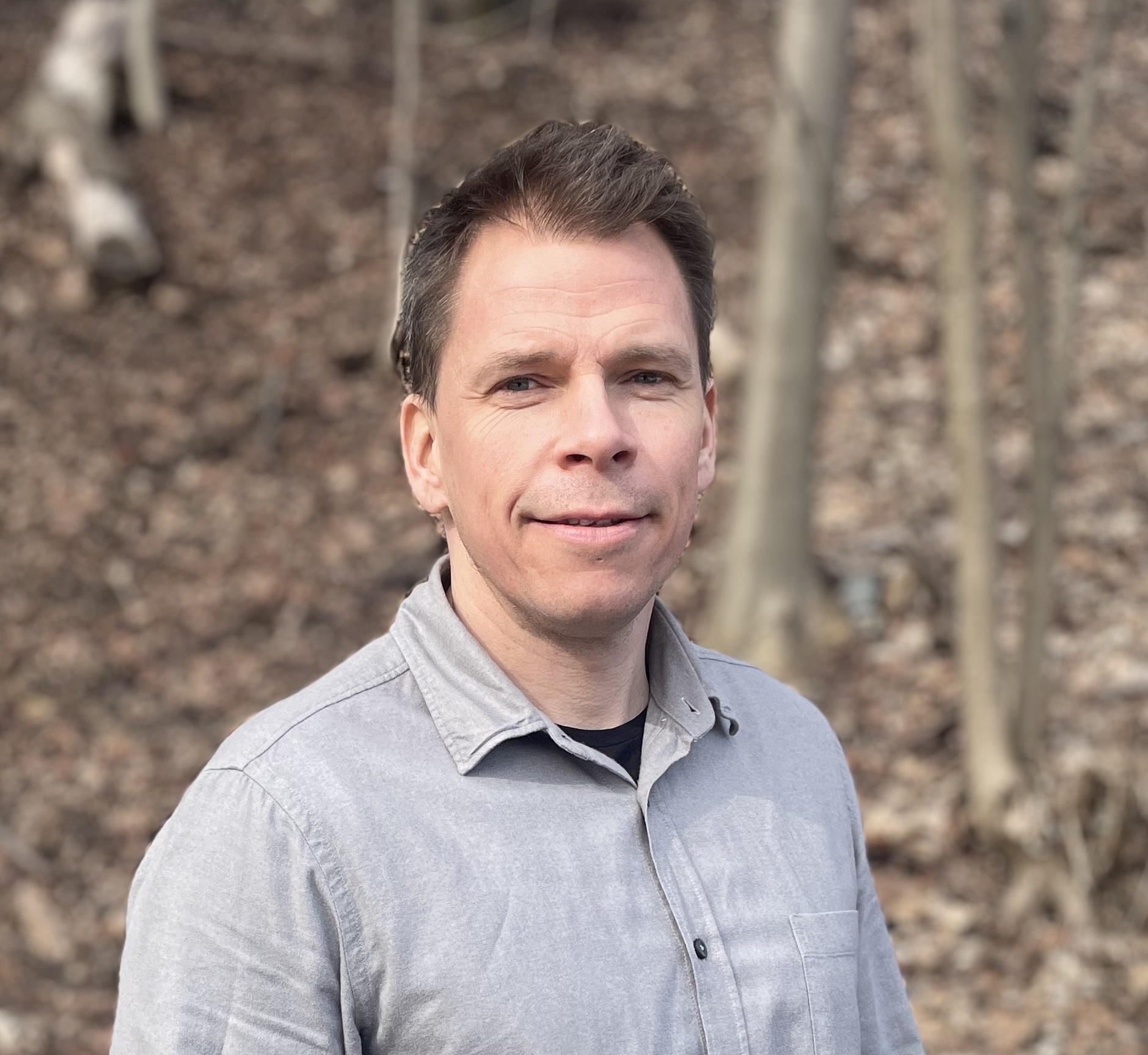 En mann som smiler til kameraet