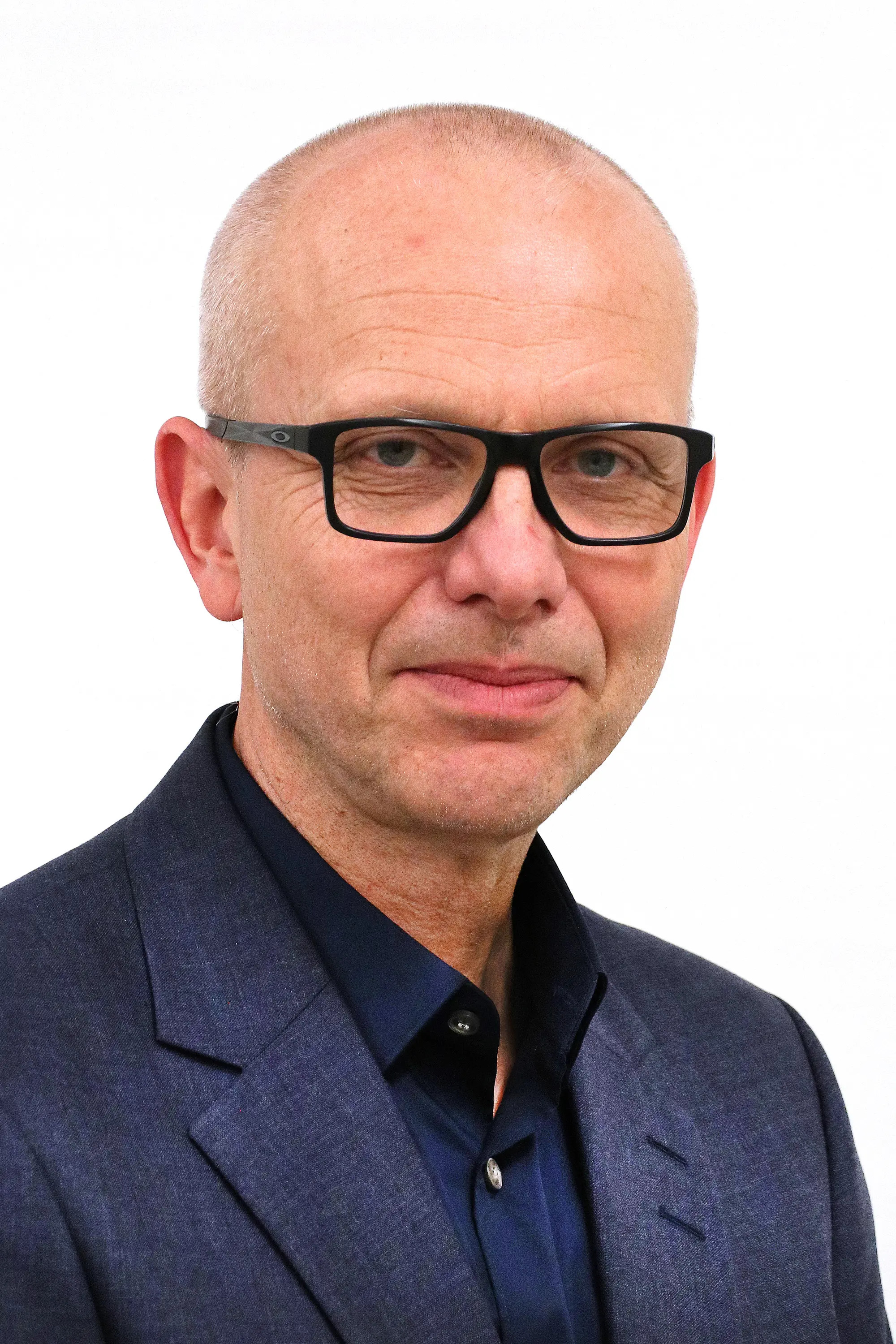 Bjørn Atle Bjørnbeth smiler mot kameraet. Han har på seg briller.