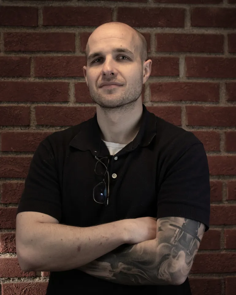 Mann foran en murvegg