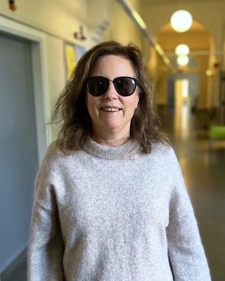 Psykologspesialist Kathrine Krydsby står smilende i en gang på Gaustad sykehus.