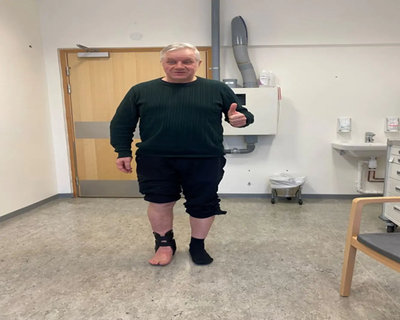 En mann viser tommel opp