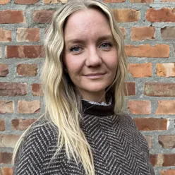 Dame foren en murvegg