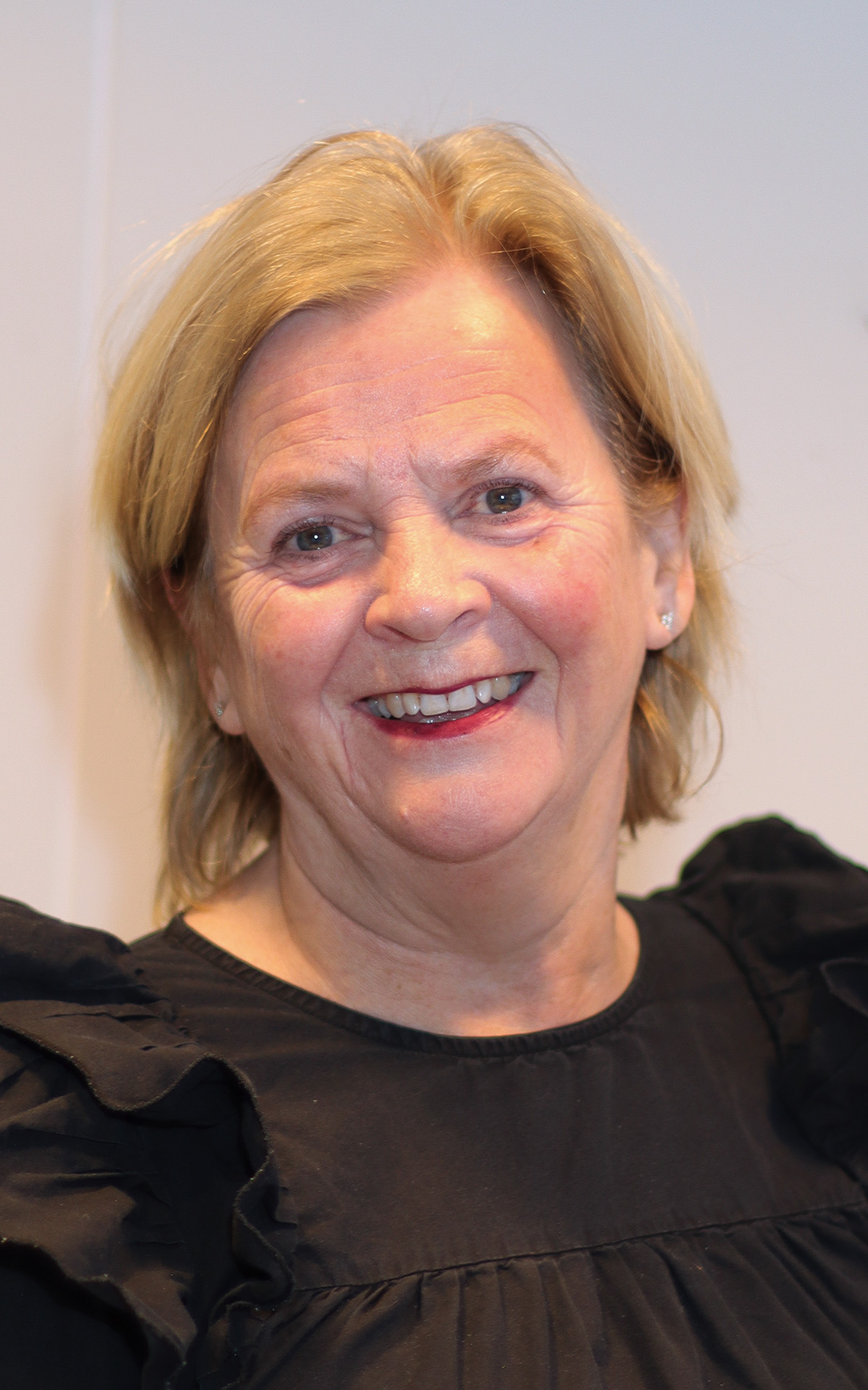 Et nærbilde av en smilende person