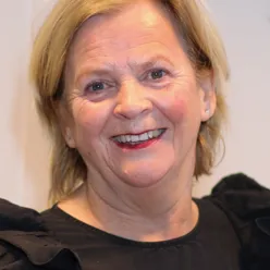 Et nærbilde av en smilende person