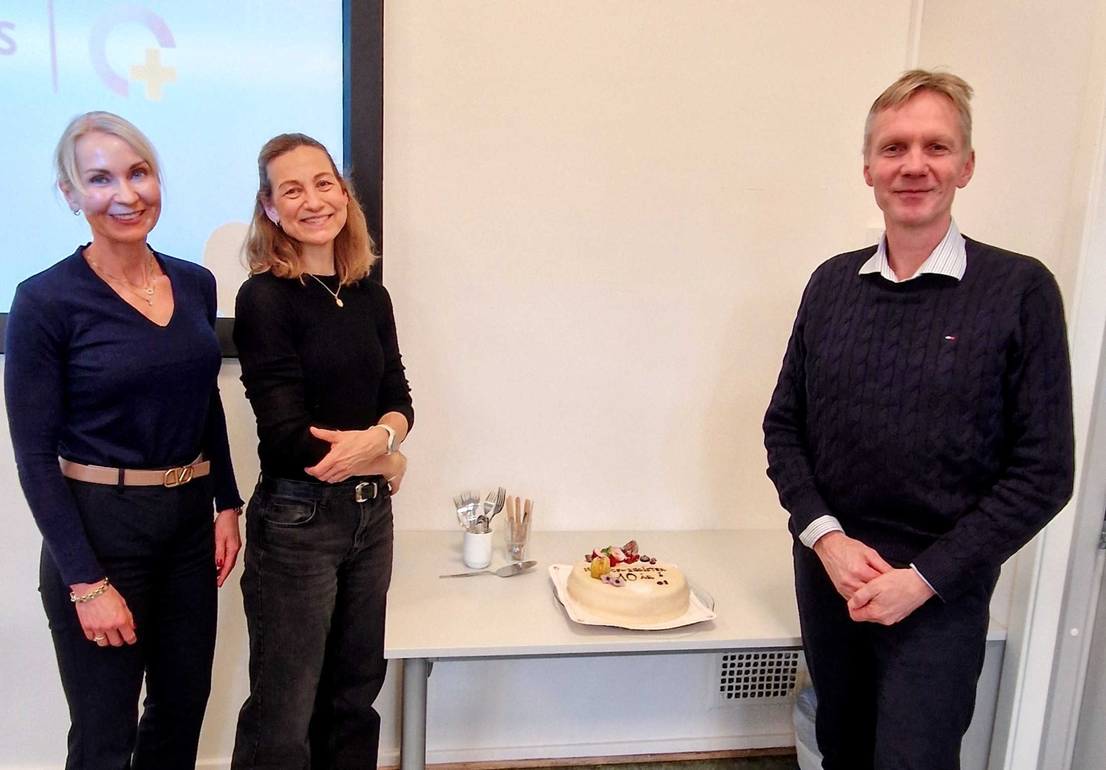 En gruppe kvinner som står ved siden av en kake