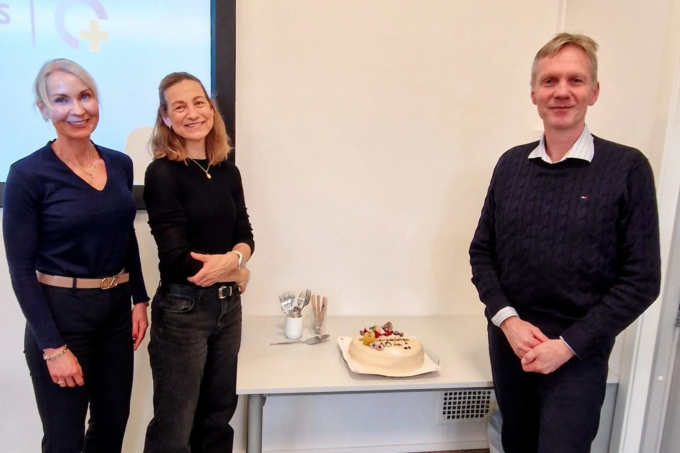 En gruppe kvinner som står ved siden av en kake