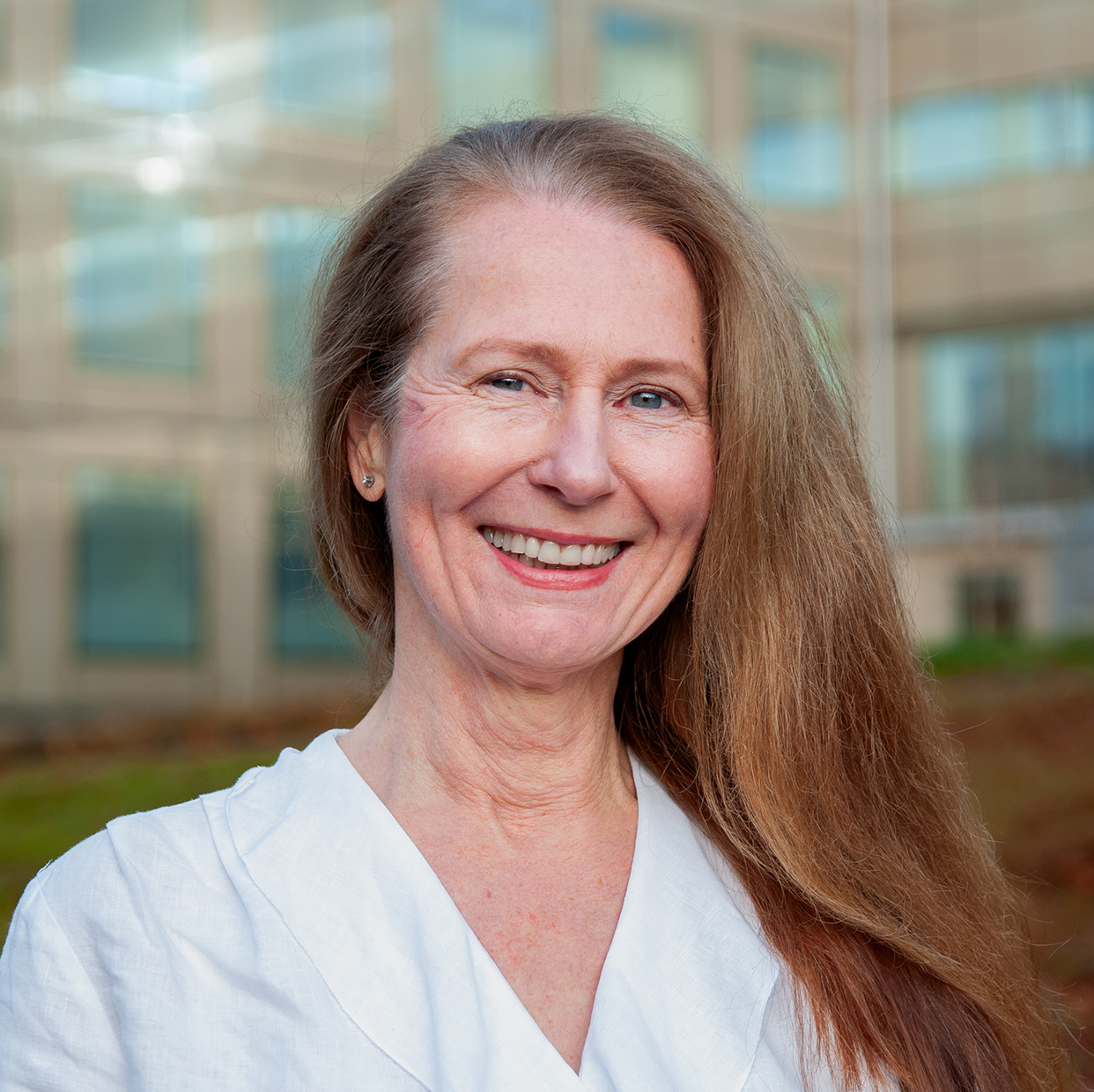 En person med langt hår som smiler