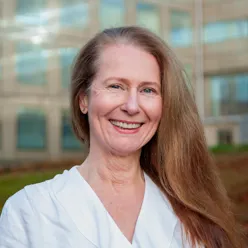 A person with long hair smiling