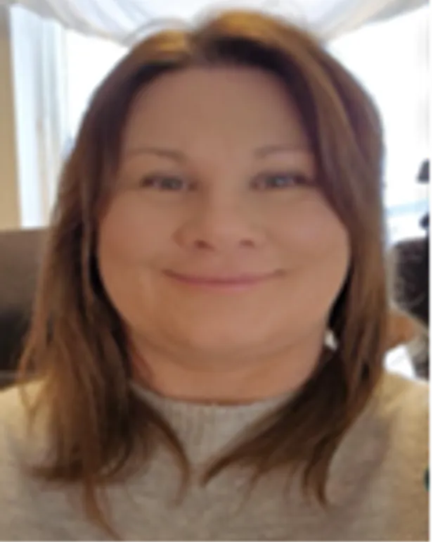 En kvinne som smiler til kameraet