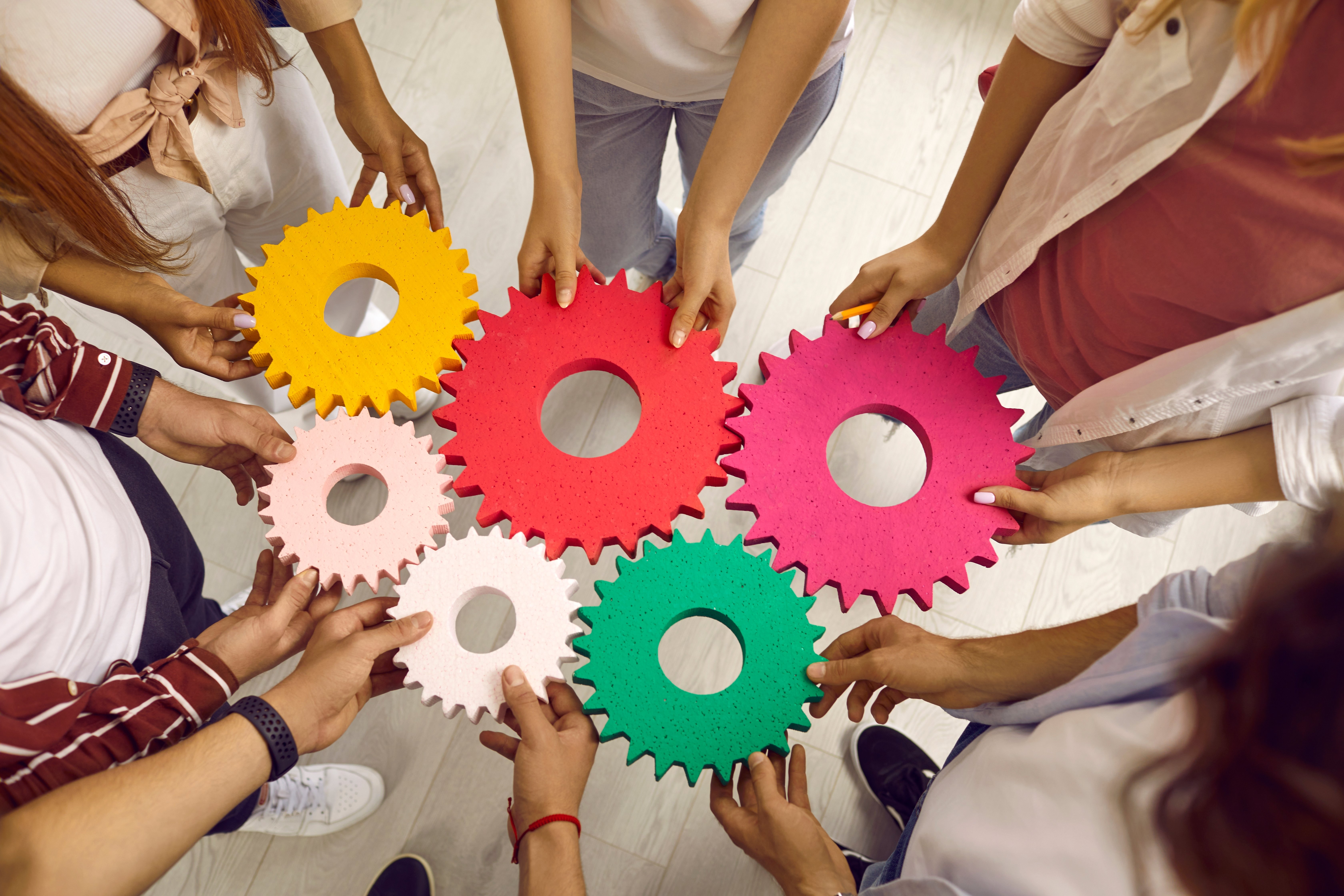 Hender som holder tannhjul inntil hverandre
