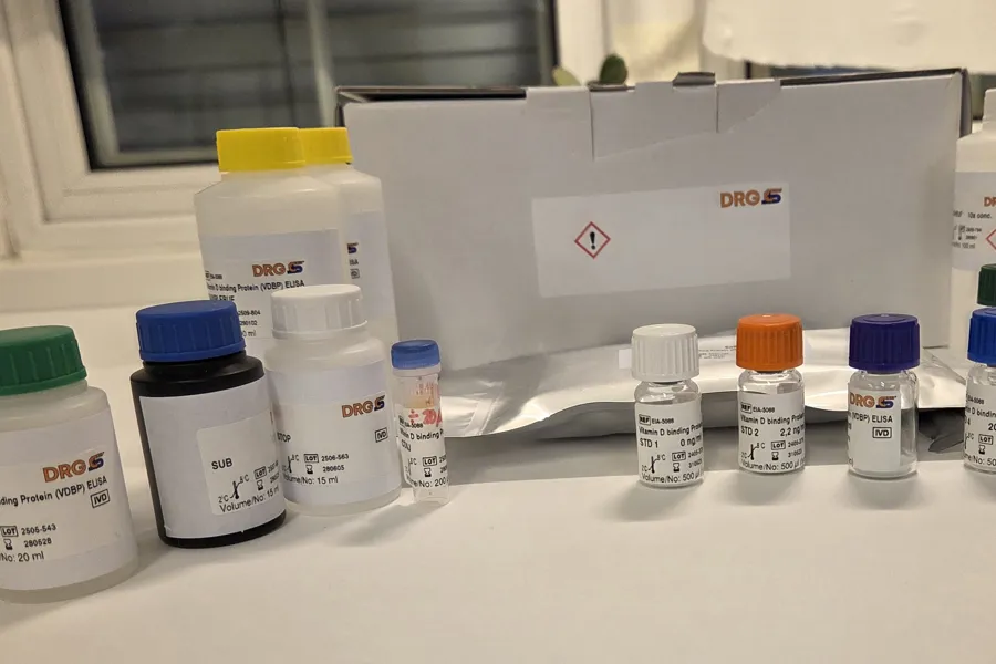 En eske med innhold: Flasker med reagenser og plate til ELISA-analyse