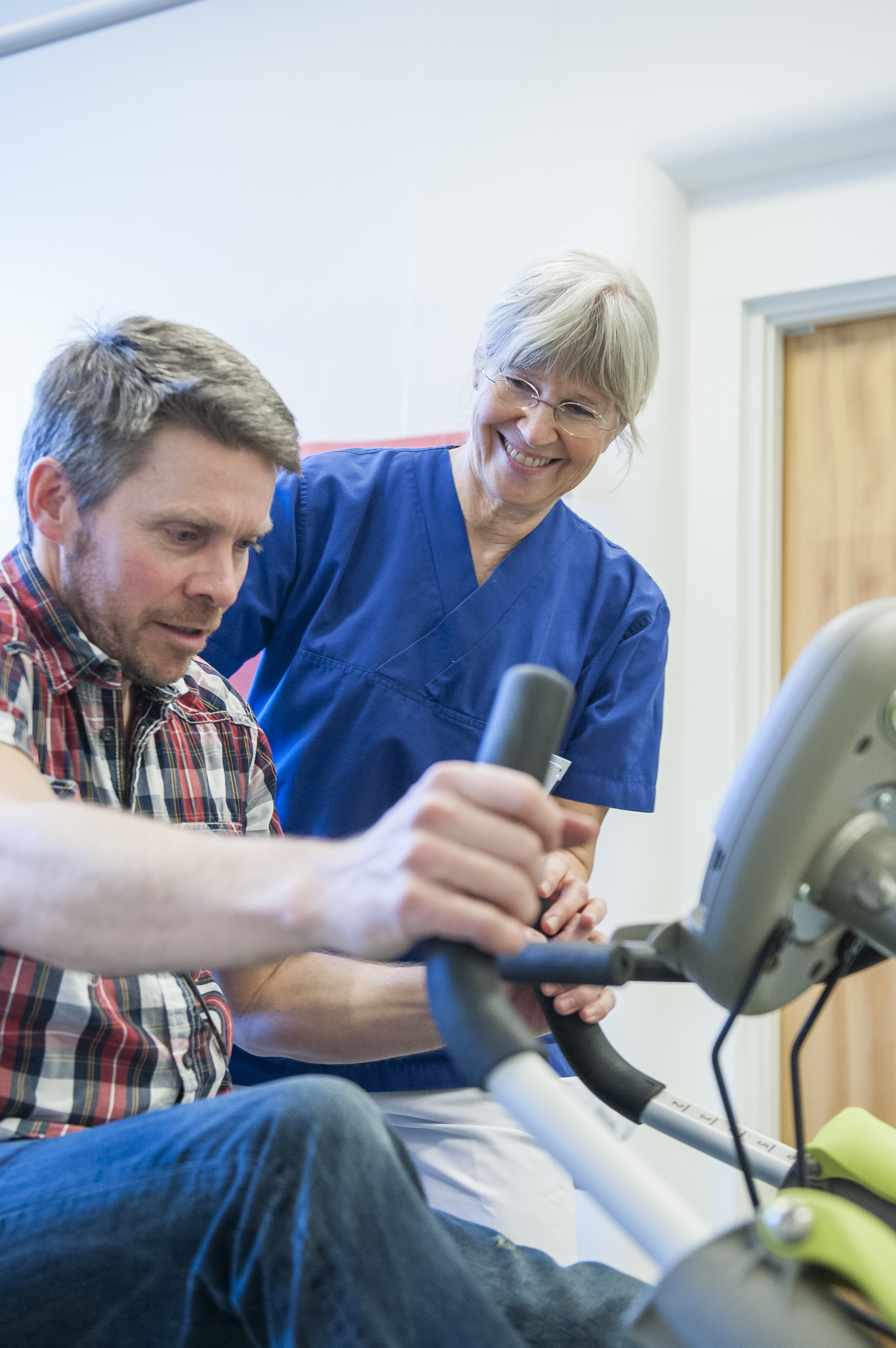 Fysioterapeut veileder pasient som trener