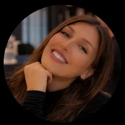 En kvinne som smiler med hånden på haken