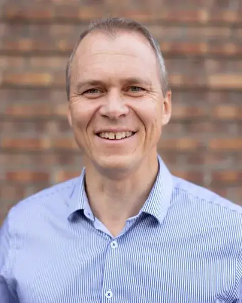 En mann som smiler til kameraet