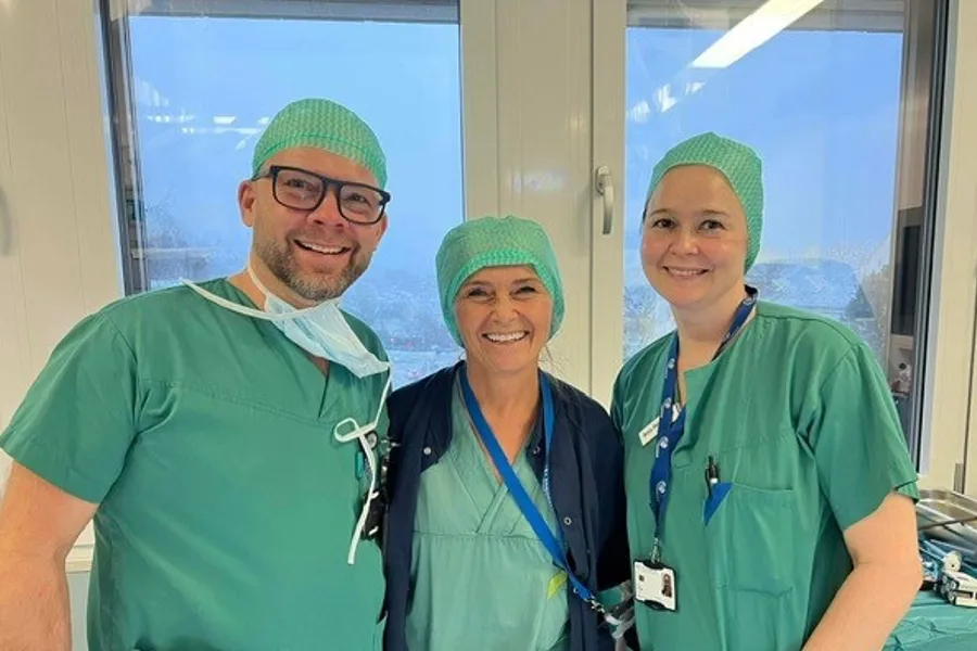 En gruppe mennesker iført kirurgiske uniformer og smilende