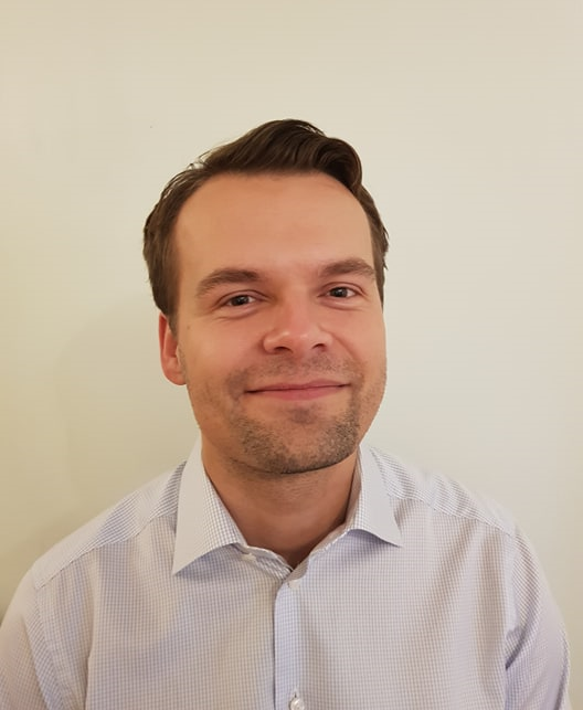 En mann som smiler til kameraet