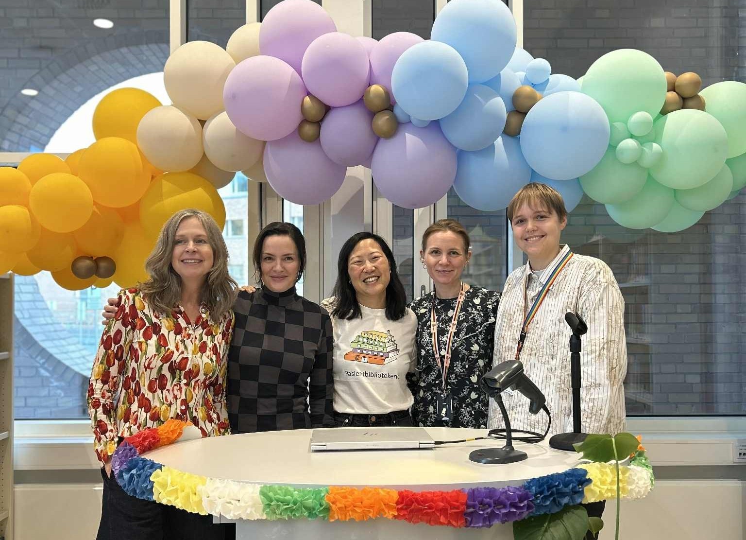 En gruppe mennesker som står ved en talerstol med ballonger