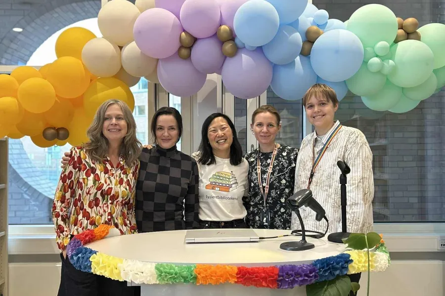 En gruppe mennesker som står ved en talerstol med ballonger