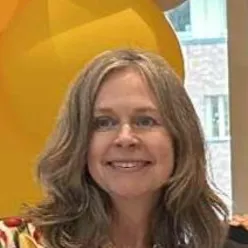 En kvinne som smiler til kameraet