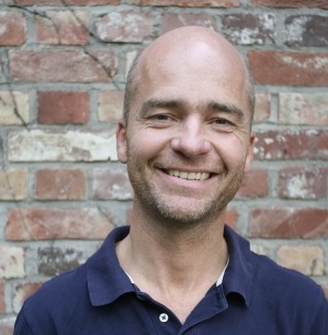 En mann som smiler til kameraet