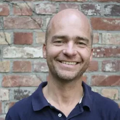 En mann som smiler til kameraet