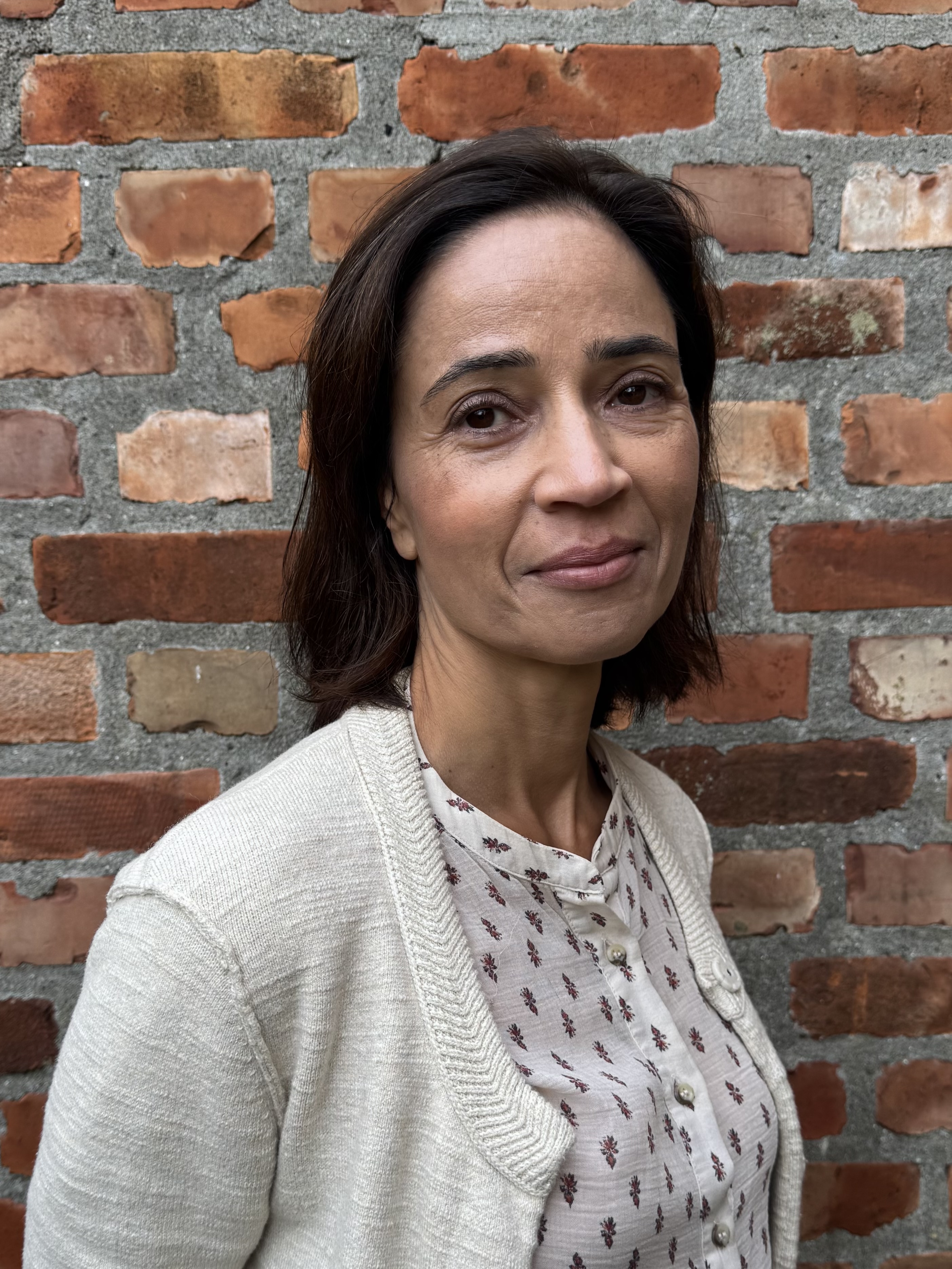 Kvinne foran en murvegg