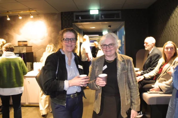 Et par kvinner som holder kopper