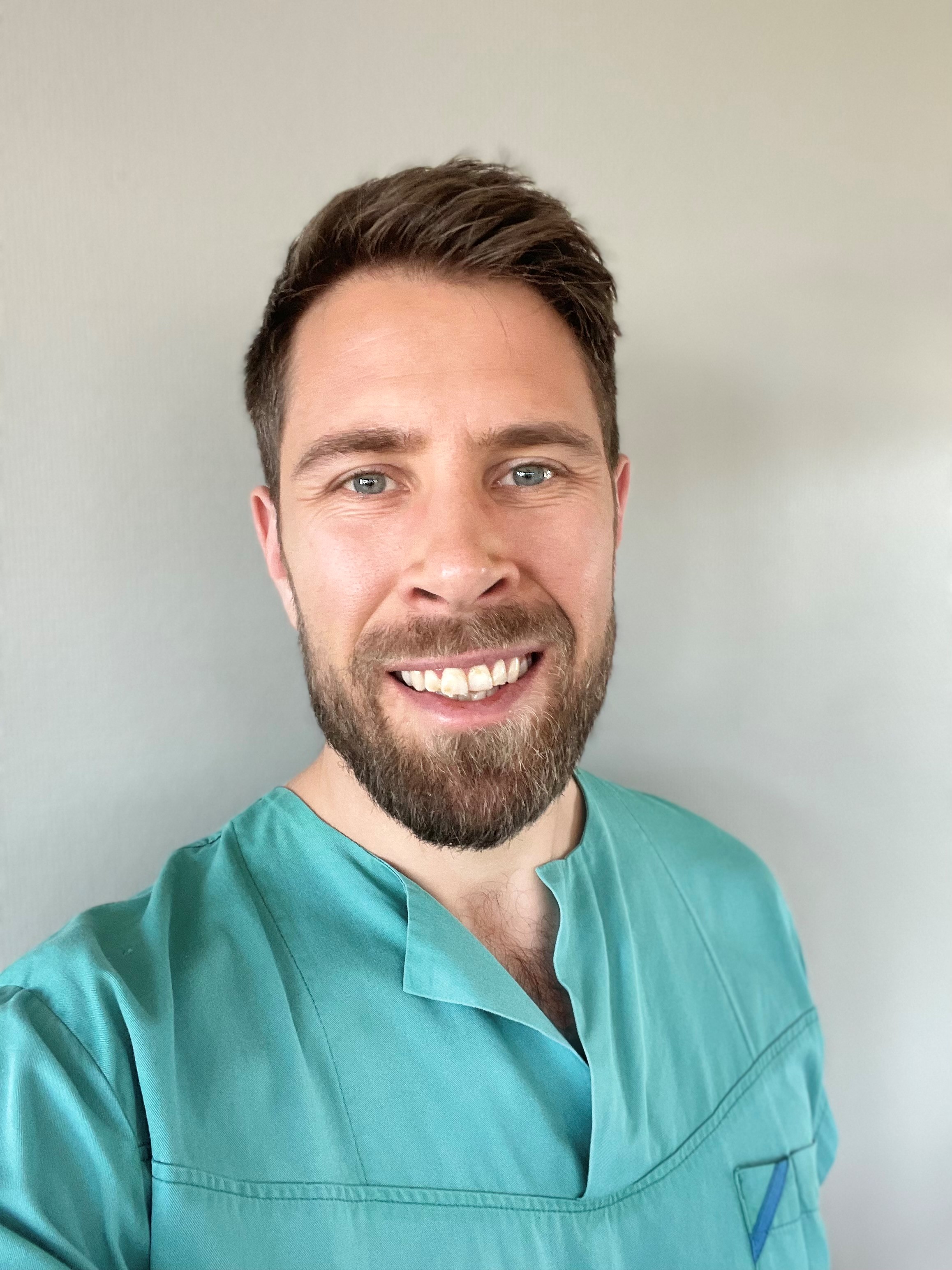 En mann som smiler til kameraet