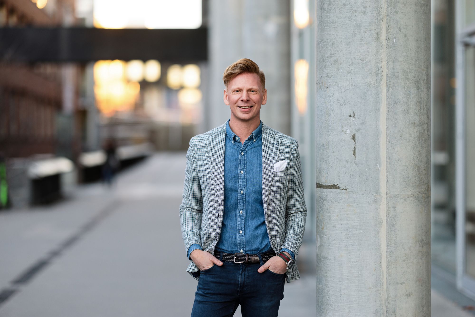 En mann som står ved siden av en søyle