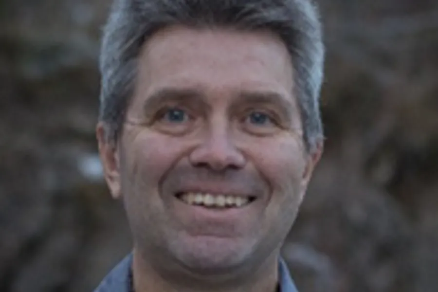 En mann som smiler til kameraet