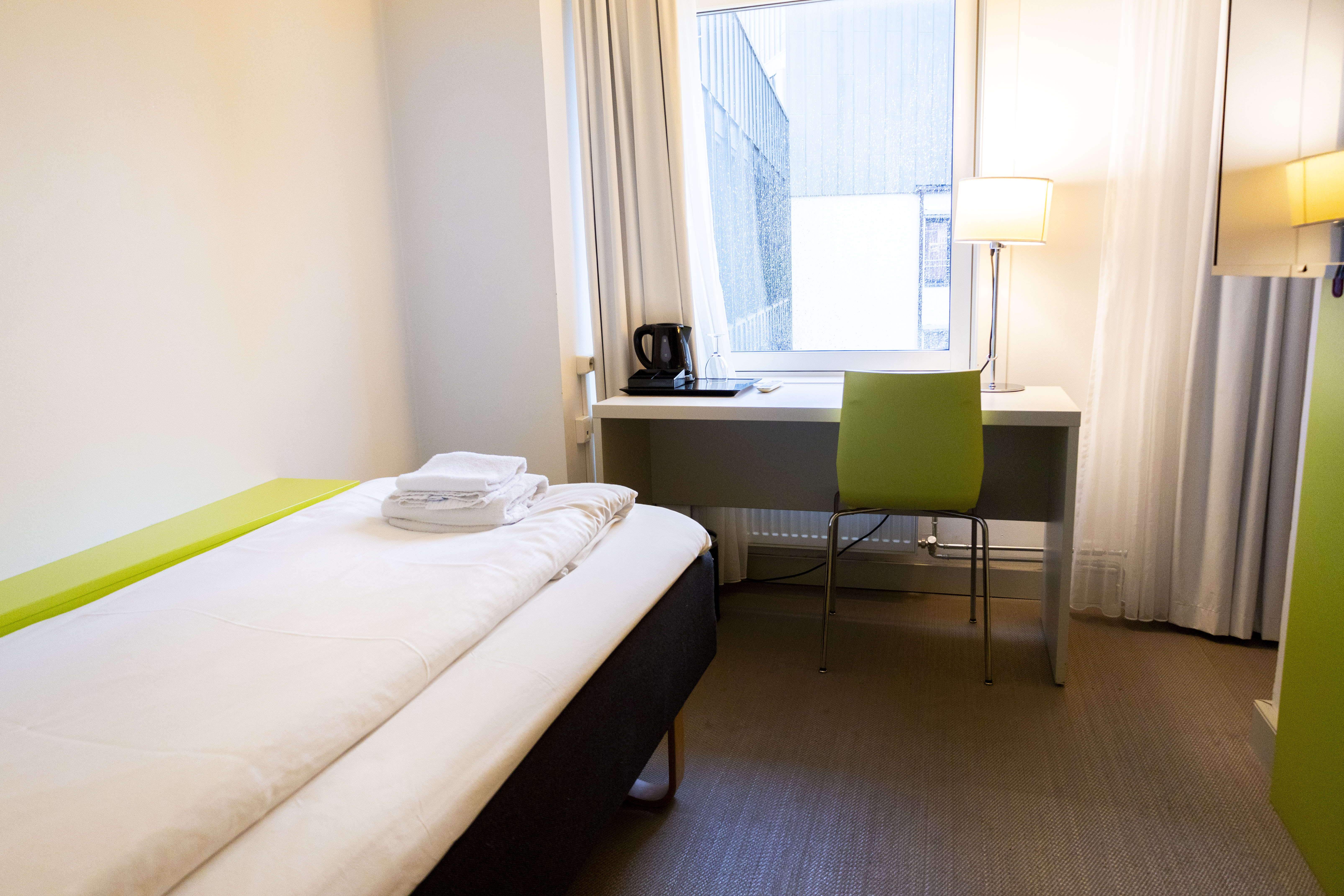 Et hotellrom med skrivebord og stol