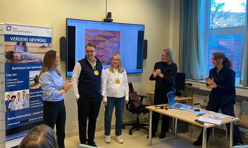 En gruppe mennesker som står foran en skjerm