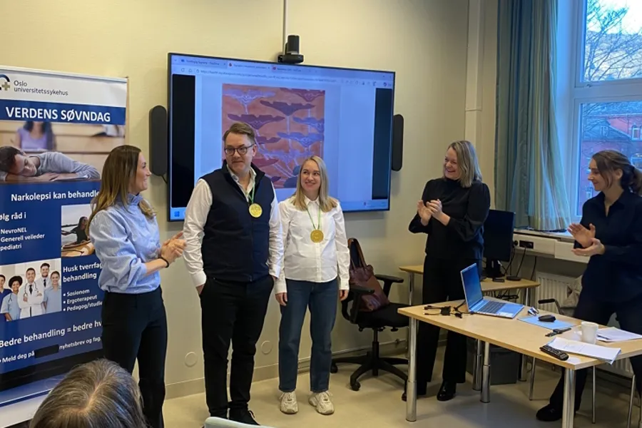 En gruppe mennesker som står foran en skjerm