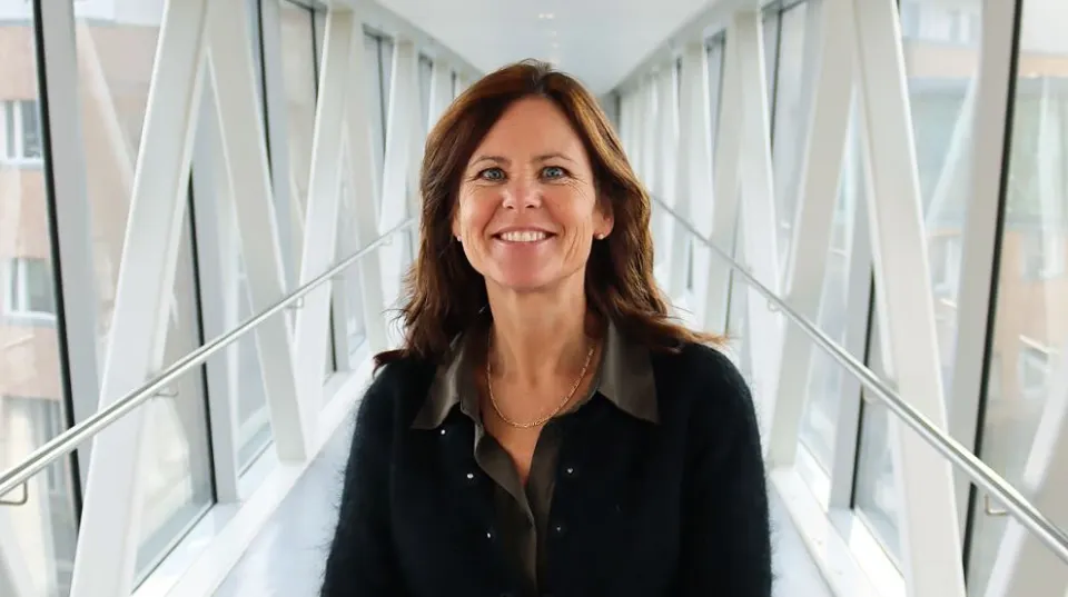 En kvinne som smiler foran en trapp