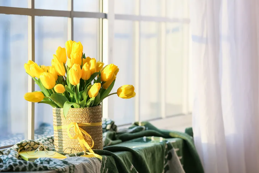 En bukett gule tulipaner i en vinduskarm