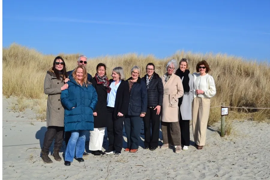 Gruppebilder på en solfylt strand. Fra venstre ser vi Camilla Stokkevåg, Grete May Engeseth, Morten Bryn, Åse Bratland, Marianne Brydøy, Marianne Grønli Guren, Berit Bø, Taran Paulsen Hellebust, Kjersti Skipar og Ingvild Mjaaland.