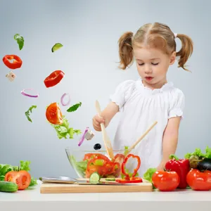 En liten jente som hakker grønnsaker