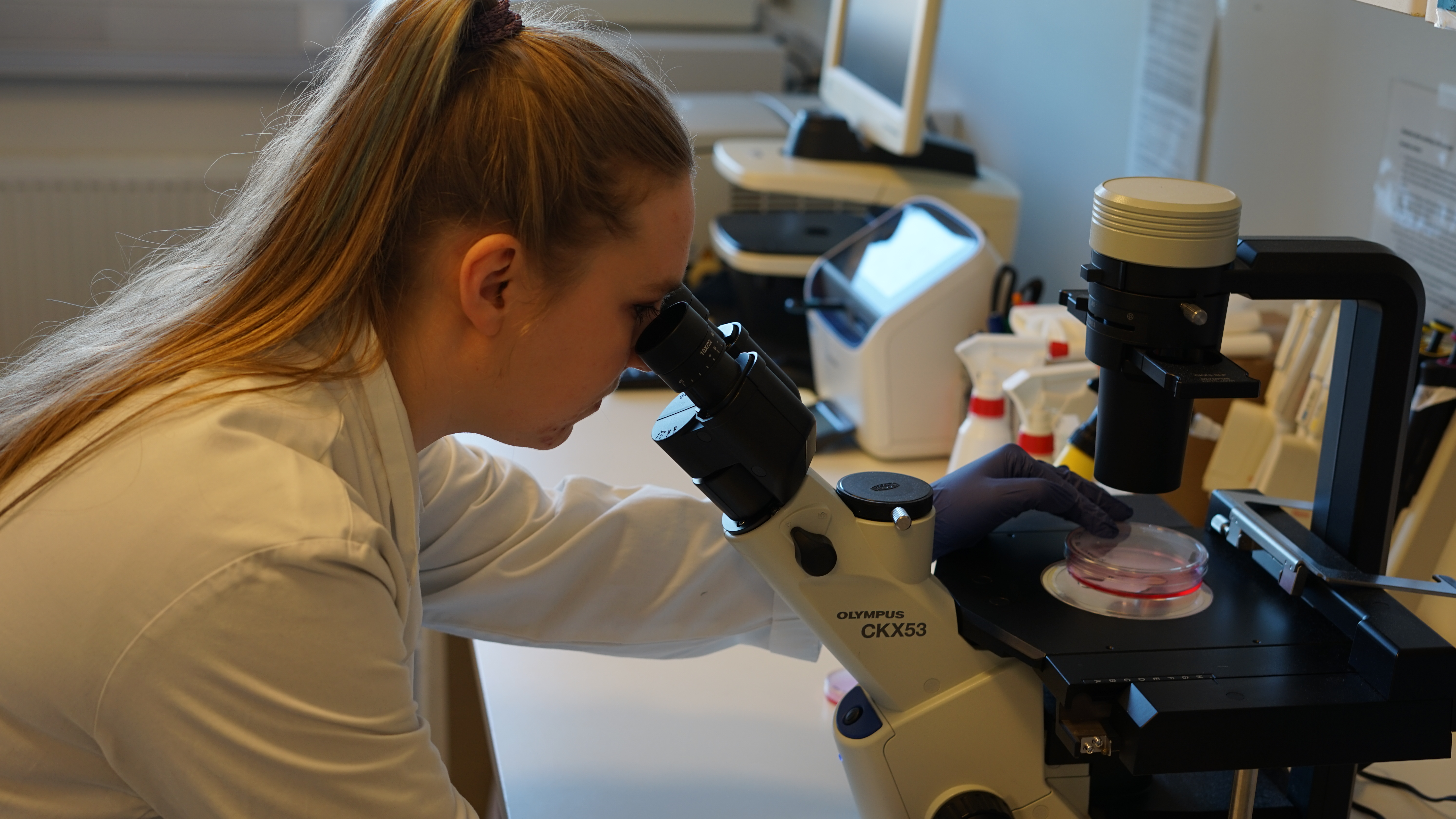 Kvinne som ser inn i et mikroskop