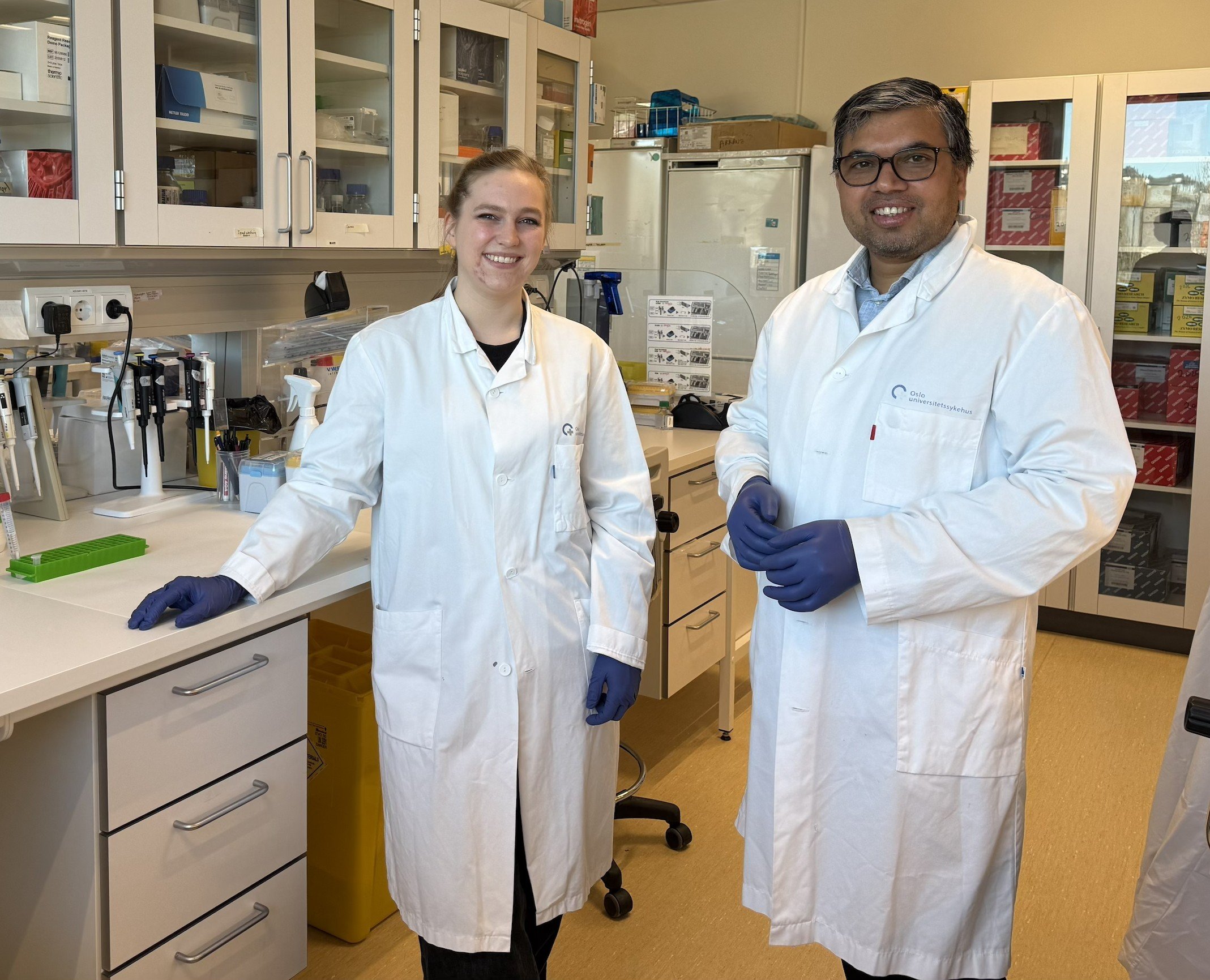 En mann og en kvinne i laboratoriefrakker i et laboratorium